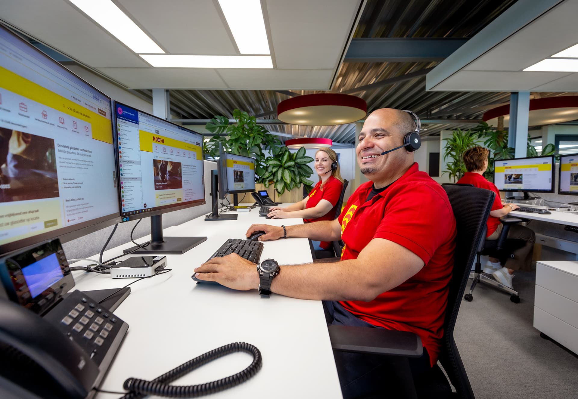 Medewerkers van het klantcontactteam werken op kantoor achter hun bureau.