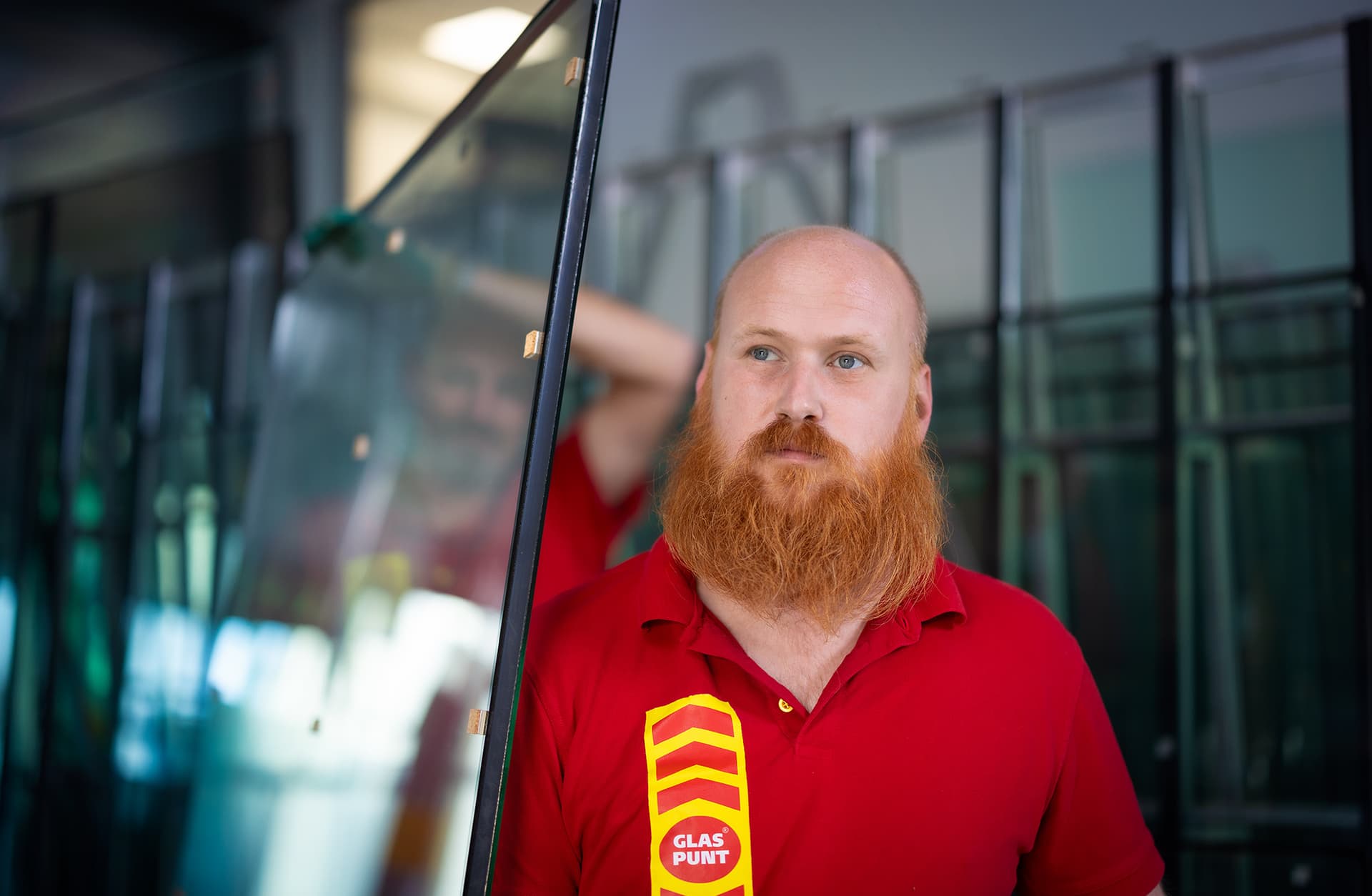 Glaszetter met baard draagt isolatieglas.