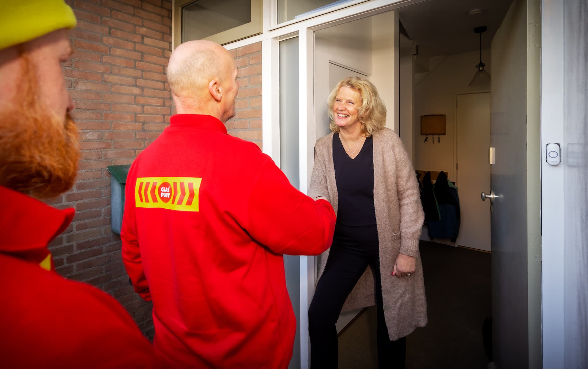 Glaszetter schudt de hand van een tevreden klant.