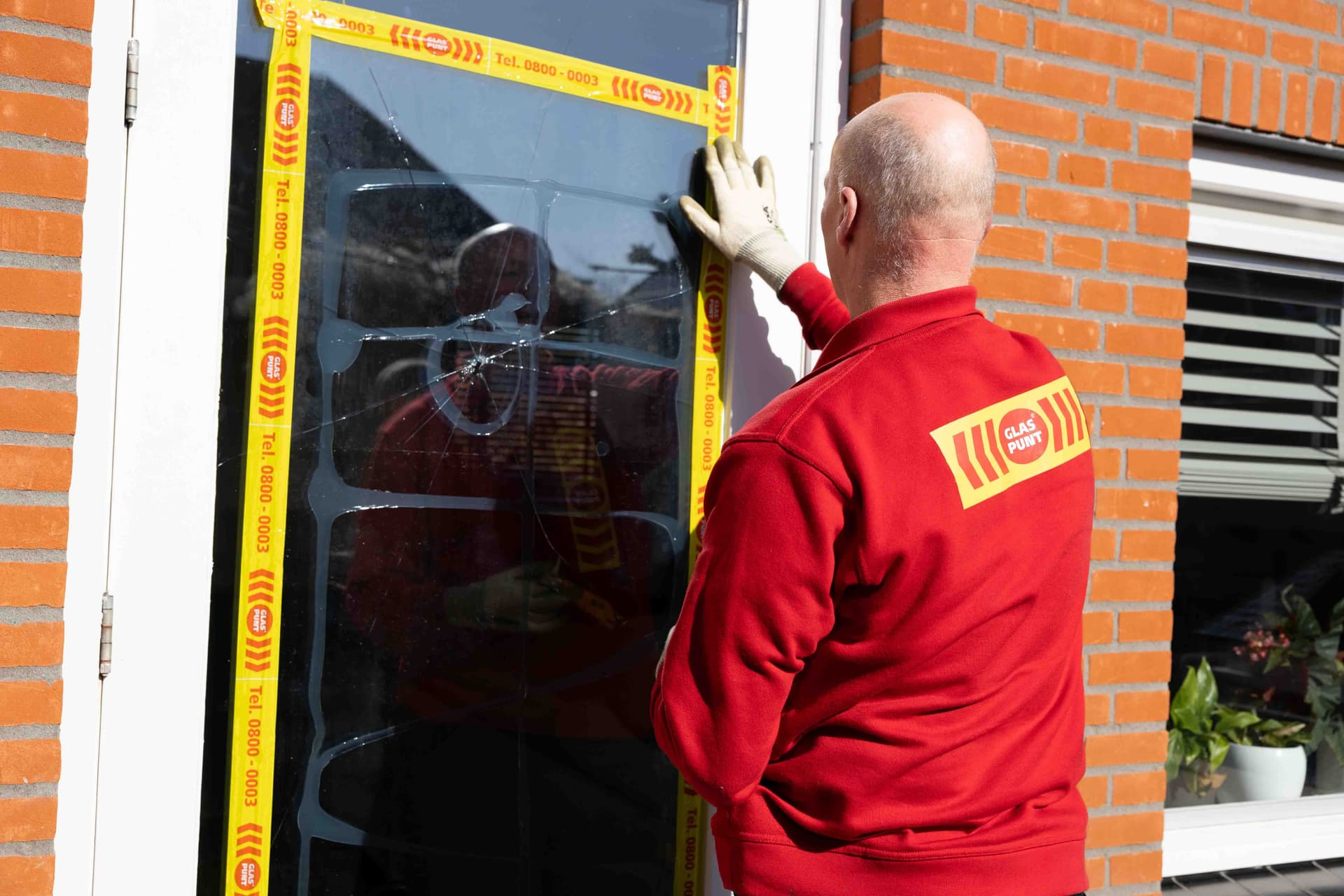 Glaszetter plaatst noodvoorziening bij glasschade