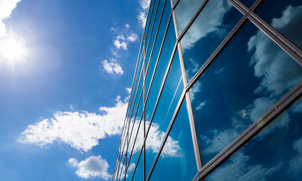 Gebouw met een glazen gevel voorzien van zonwerend glas in het zonlicht.