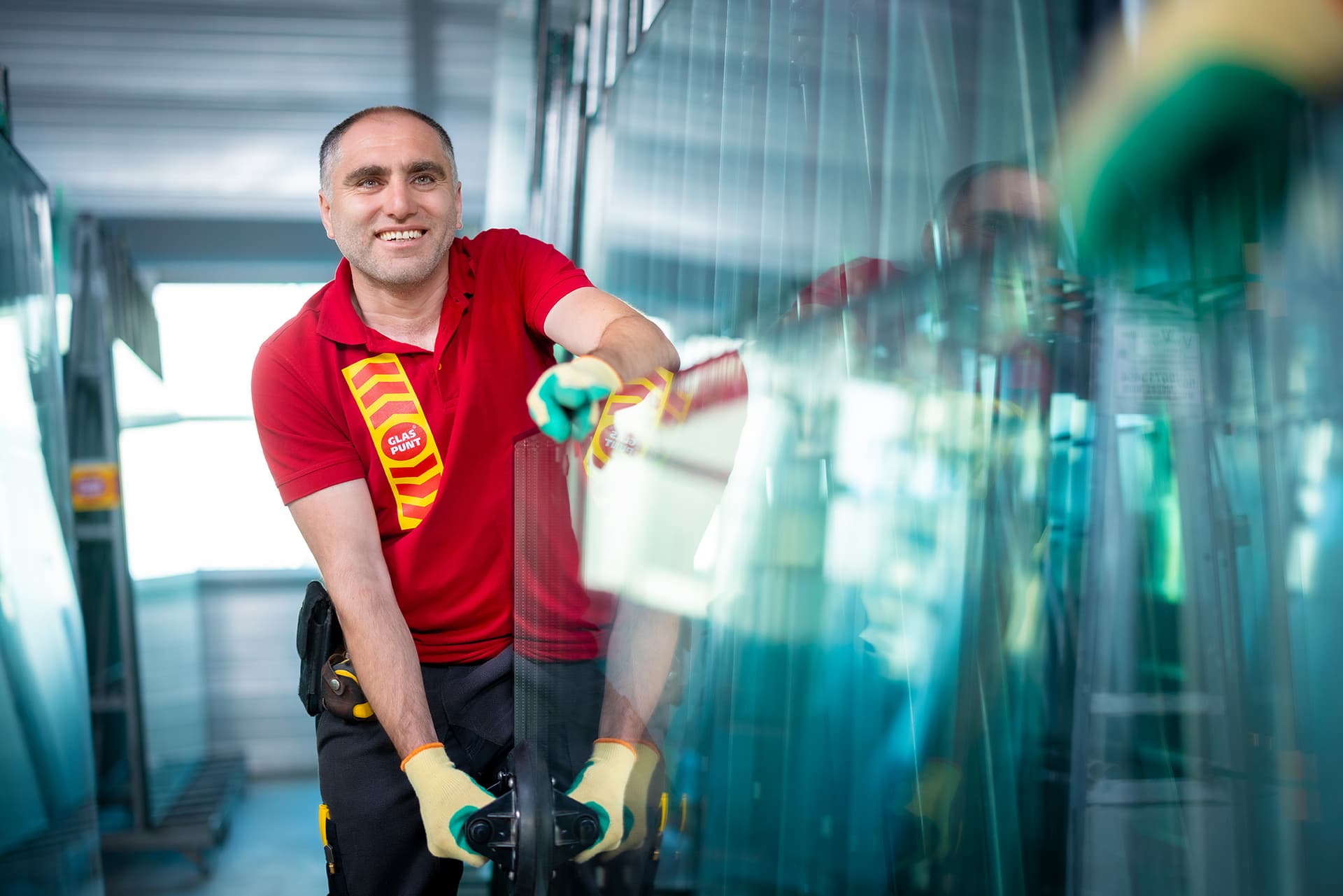 Glaszetter draagt dubbel glas in een werkruimte.